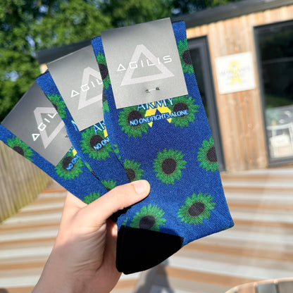 Person holding a blue patterned pouch with morgans army logo outdoors