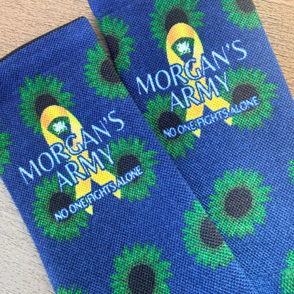 Blue socks with green floral patterns and 'Morgan's Army' branding on a wooden surface.